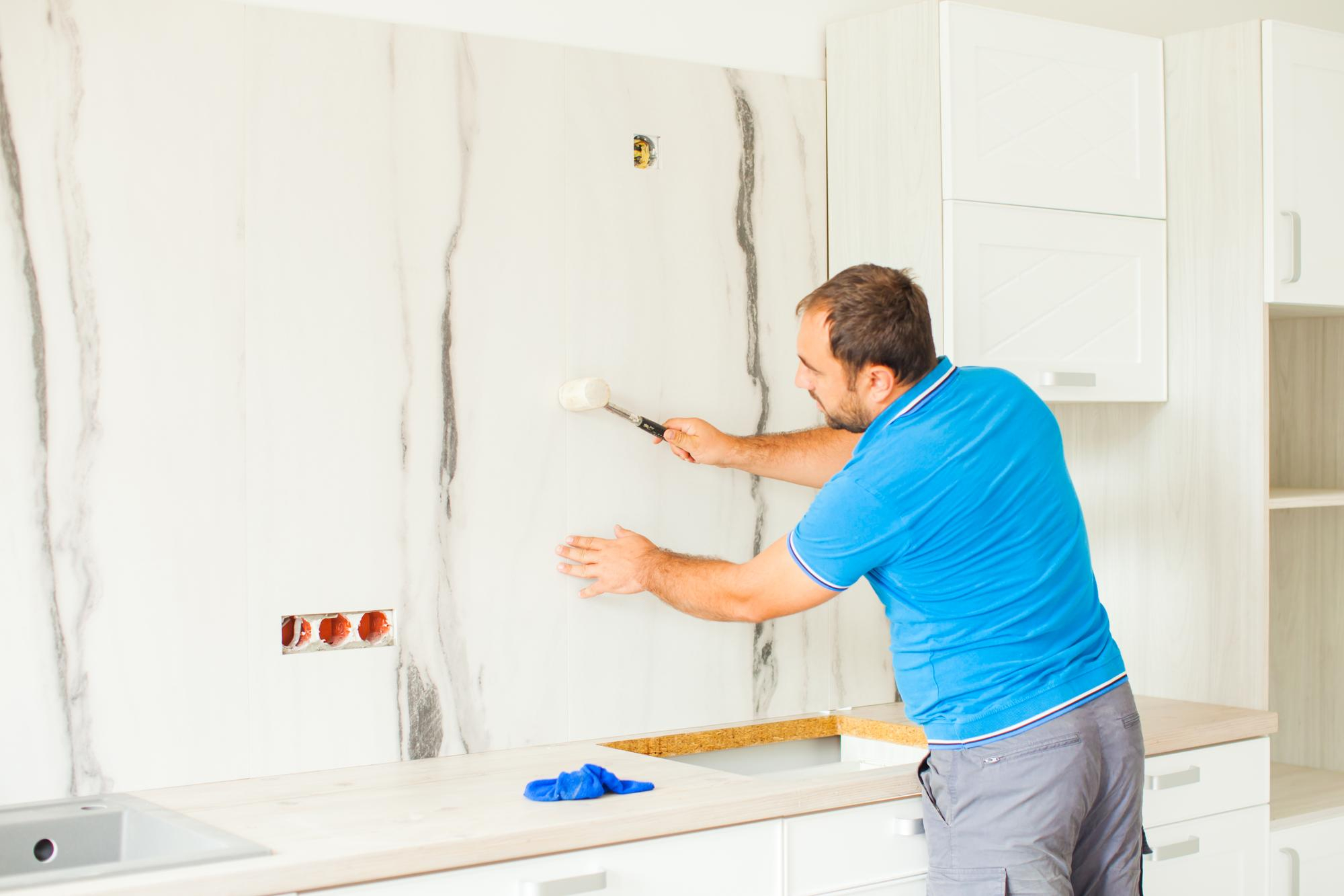 Kitchen renovation in progress with white cabinets being prepared for painting