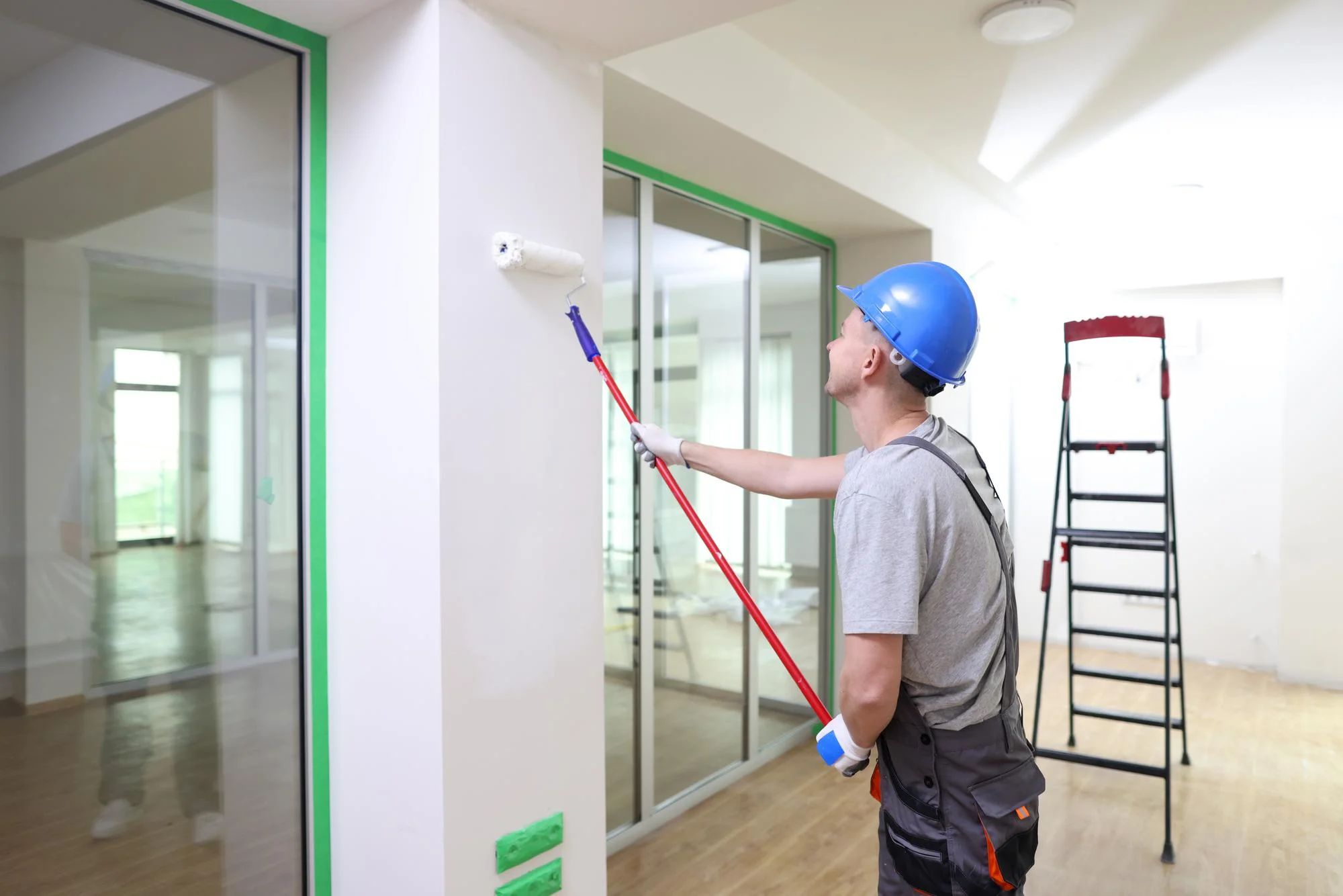 Professional painter painting interior wall in a modern office building