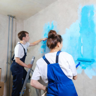 Professional painters applying blue paint to an interior wall during a home painting project